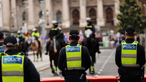 Victoria Police officers patrolling the streets of Melbourne CBD near Flinders Street Station during the day.