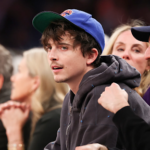 Timothée Chalamet wearing an orange suit at the Marty Supreme premiere looking overly confident.