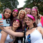 Rebel Wilson smiling and waving to a crowd of fans outside the Sydney Federal Court during her defamation trial.