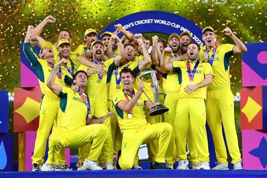 The Australian national football team celebrating a crucial goal under the stadium lights at the World Cup.