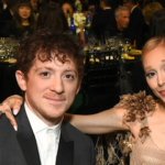 Pop star Ariana Grande and Broadway actor Ethan Slater smiling side-by-side at a high-profile red carpet event.