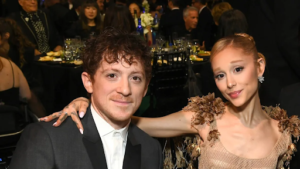 Pop star Ariana Grande and Broadway actor Ethan Slater smiling side-by-side at a high-profile red carpet event.