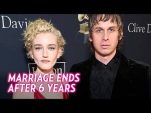 Actress Julia Garner and musician Mark Foster posing together smiling at a Hollywood red carpet event.