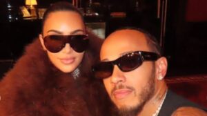 Kim Kardashian and Lewis Hamilton walking together on a sandy beach during their romantic summer family getaway.