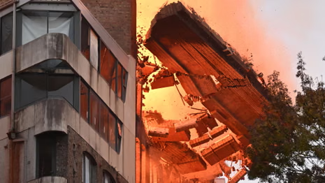 Emergency services surrounded by fallen brick rubble and crushed vehicles on Wattle Street during Ultimo collapse.