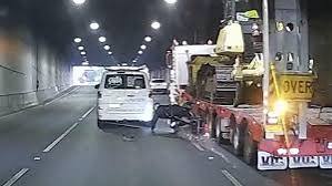 Dashcam frame showing motorcyclist dragged by oversized truck in Melbourne tunnel.